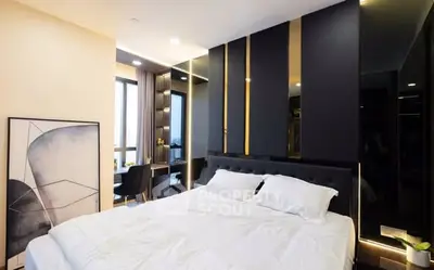 Luxurious modern bedroom with elegant decor and large window view.