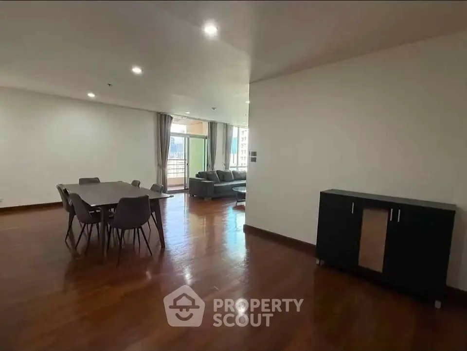 Spacious open-plan living and dining area with modern furniture and large windows.