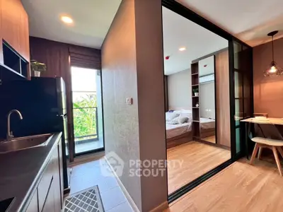 Modern apartment interior with sleek kitchen and cozy bedroom, featuring stylish decor and natural light.