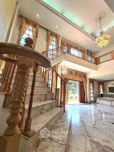 Luxurious marble staircase in elegant living room with high ceilings and chandelier