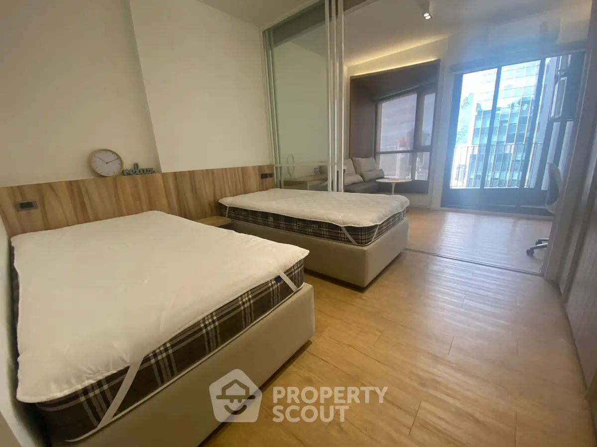 Modern bedroom with twin beds and balcony view in urban apartment