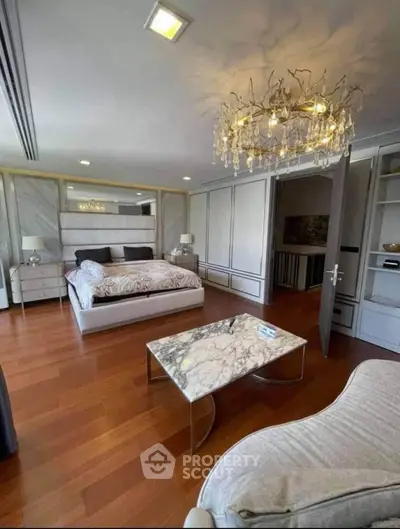 Luxurious bedroom with elegant chandelier and marble accents in modern apartment