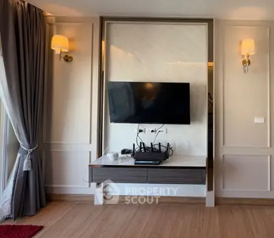 Modern living room with wall-mounted TV and elegant lighting fixtures.