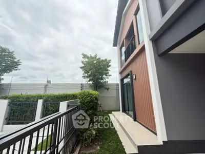 Modern two-story house with sleek exterior design and lush garden area.