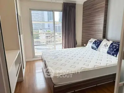 Modern bedroom with large window and city view, featuring a stylish bed and wooden flooring.