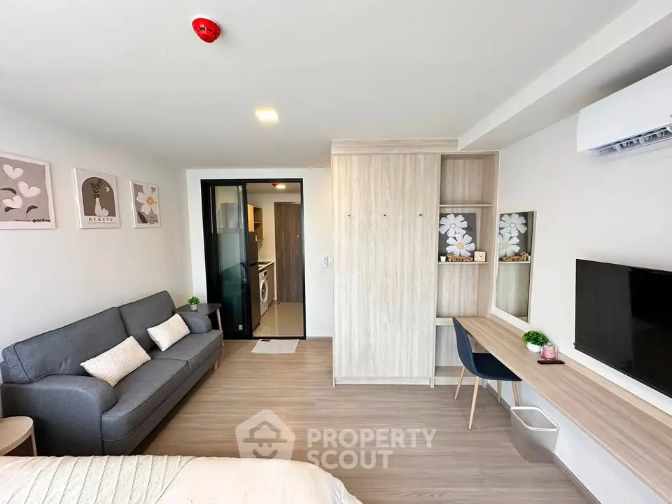 Modern studio apartment with stylish decor, featuring a cozy living area, sleek furniture, and a compact kitchen.