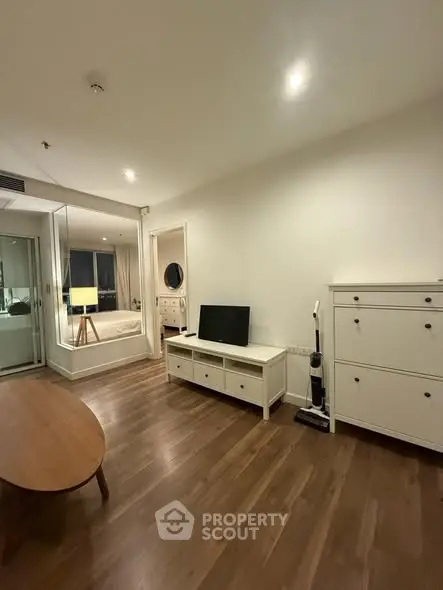 Modern living room with wooden flooring and sleek white furniture