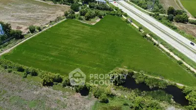 Expansive green land plot near highway ideal for development opportunities