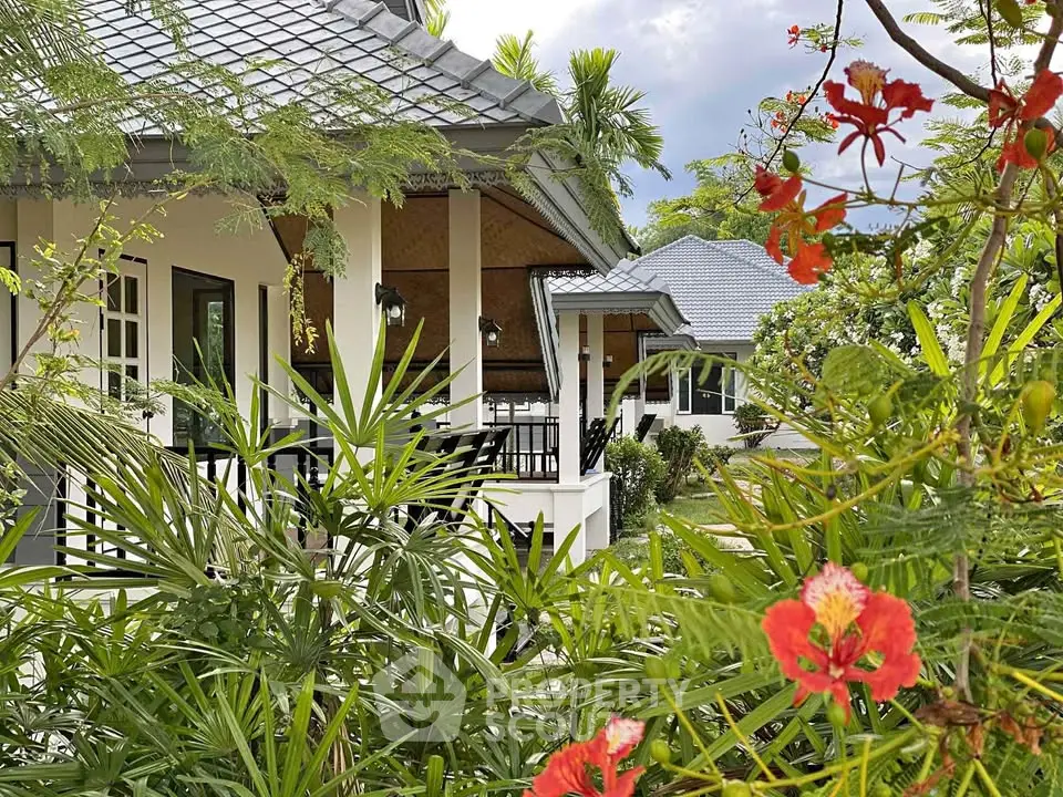 Charming tropical house with lush garden and modern architecture, perfect for serene living.