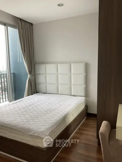 Modern bedroom with large window and stylish headboard in urban apartment