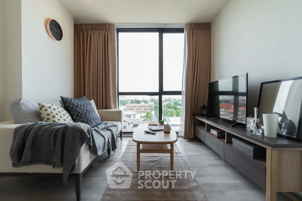 Modern living room with large window and stylish decor, offering a cozy and inviting atmosphere.