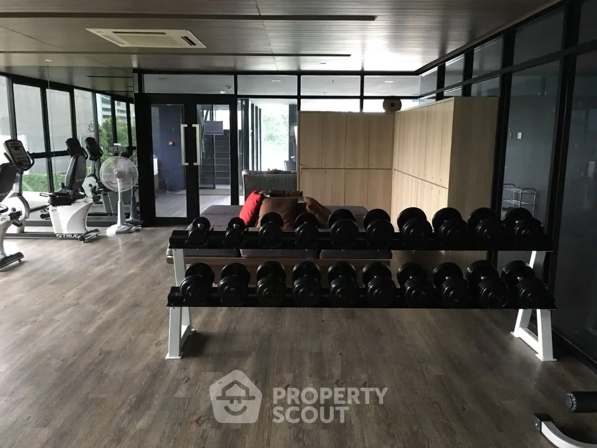 Modern gym with sleek wooden flooring and ample natural light