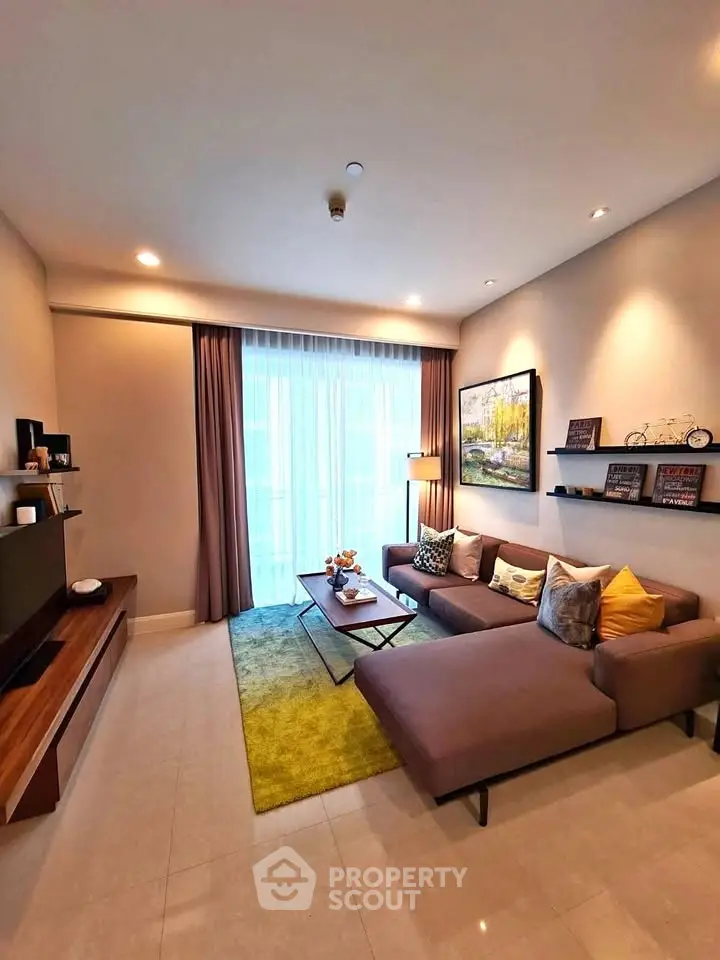 Modern living room with stylish decor and natural light, featuring a cozy sectional sofa and entertainment unit.