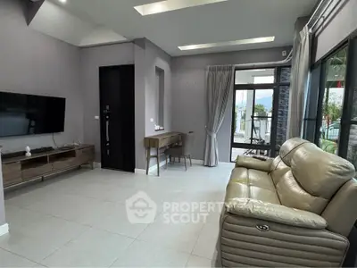 Modern living room with sleek furniture and large windows offering natural light and scenic views.