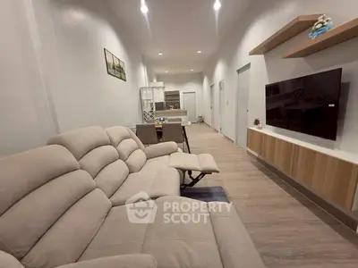 Spacious modern living room with cozy beige sofas and wall-mounted TV, perfect for relaxation.
