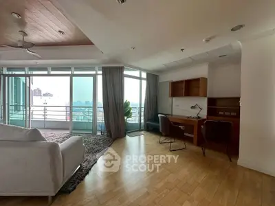 Spacious living room with city view and study area, featuring modern furniture and floor-to-ceiling windows.