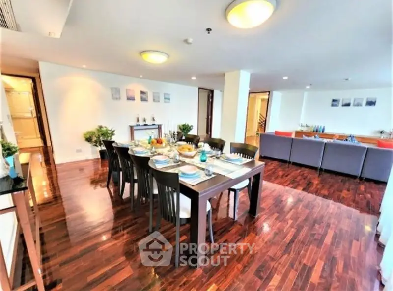 Spacious dining and living area with elegant wooden flooring and modern decor.