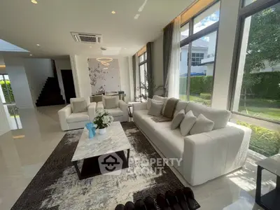Luxurious living room with modern decor, large windows, and elegant furniture in a bright, spacious home.