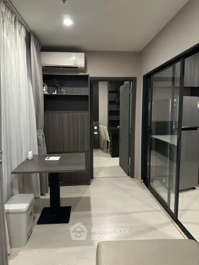 Modern apartment interior with sliding glass doors and sleek furniture design.