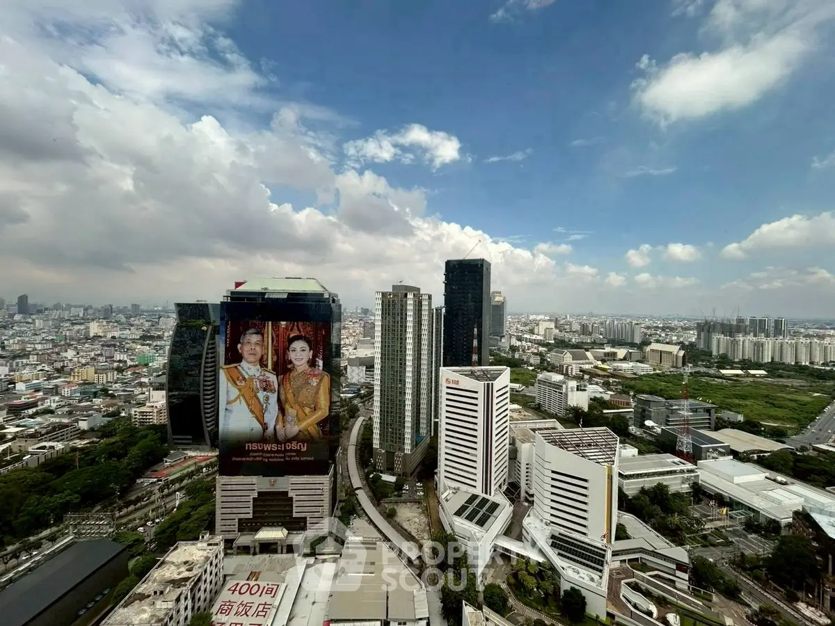 Stunning cityscape view with modern skyscrapers and lush greenery under a vibrant blue sky.