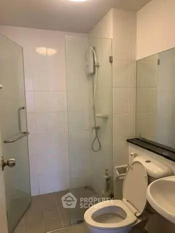 Modern bathroom with glass shower enclosure and sleek fixtures.