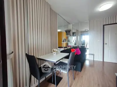 Modern living room with stylish striped wallpaper and cozy dining area.