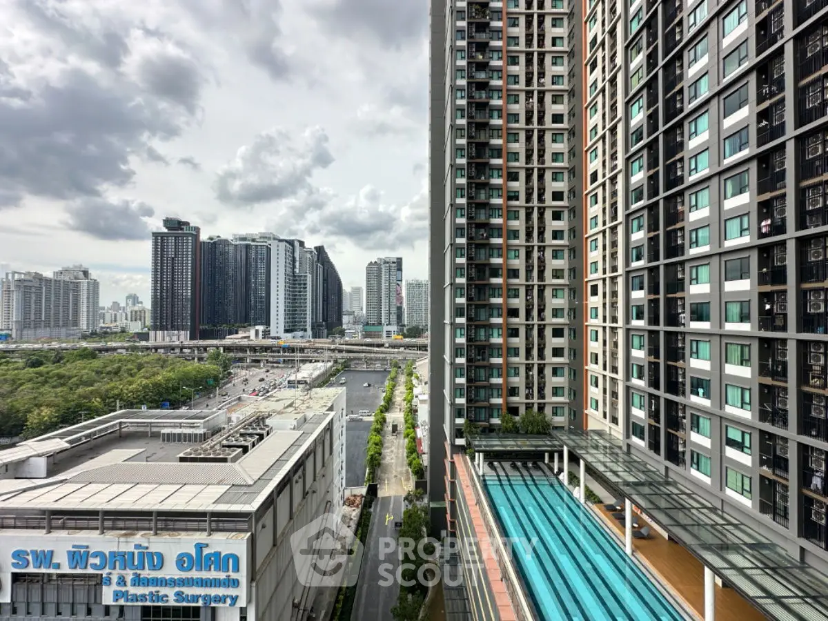 Stunning cityscape view from high-rise building with pool and modern architecture.