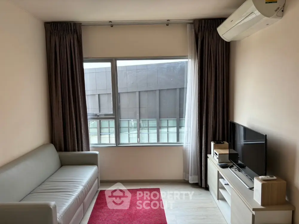 Modern living room with sleek sofa, red rug, and wall-mounted air conditioning