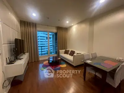 Spacious living room with modern decor and city view, featuring hardwood floors and cozy seating area.
