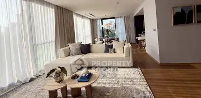 Spacious modern living room with elegant decor and large windows offering natural light.