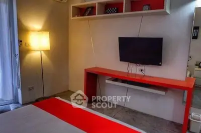 Modern bedroom with red accents, wall-mounted TV, and ambient lighting.