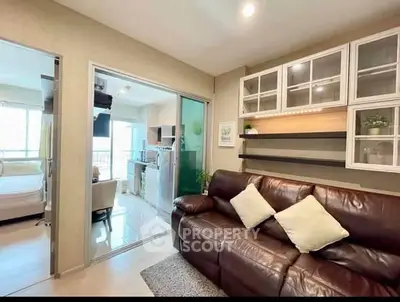 Modern living room with leather sofa and open kitchen layout in cozy apartment.