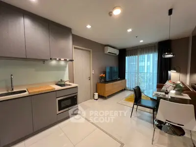 Modern open-layout kitchen and living room with sleek design and natural light.