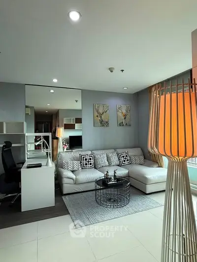 Modern living room with stylish decor and large windows offering natural light.