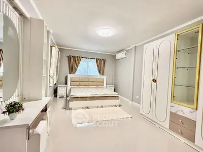 Spacious bedroom with elegant decor and large window for natural light