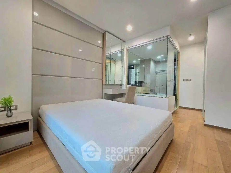 Modern bedroom with sleek design and glass partition in luxury apartment.