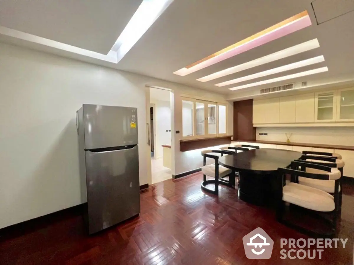 Spacious dining area with modern lighting and sleek refrigerator