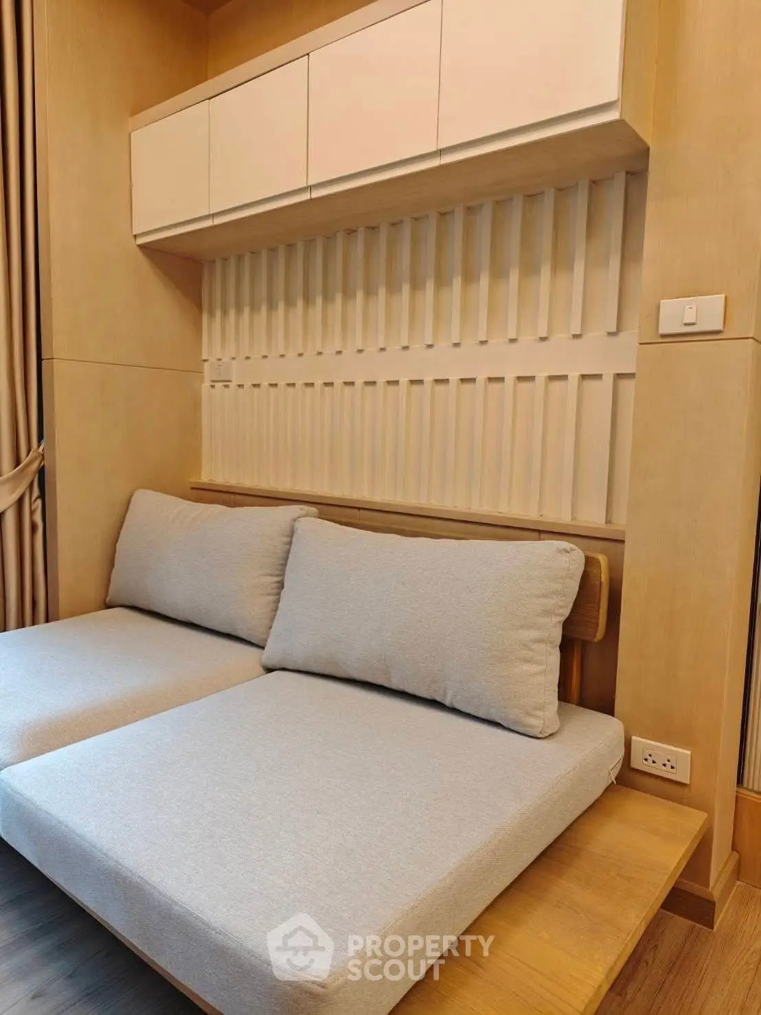 Modern bedroom with stylish wooden paneling and cozy seating area