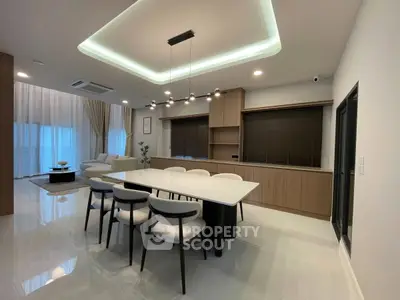 Modern open-plan living and dining area with elegant lighting and stylish furnishings.
