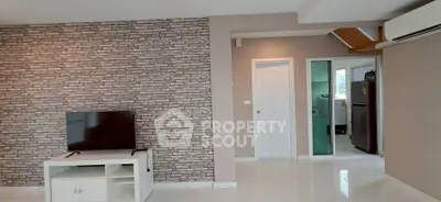 Modern living room with brick accent wall and sleek TV setup