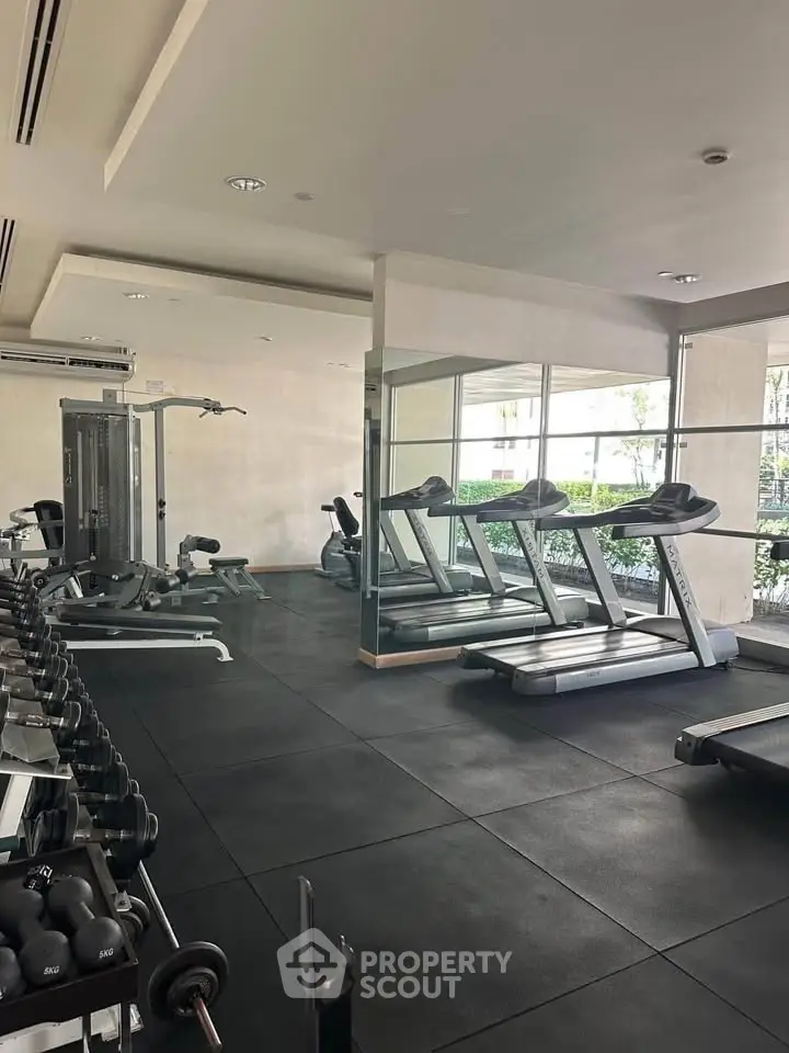 Modern gym with treadmills and weights in a residential building