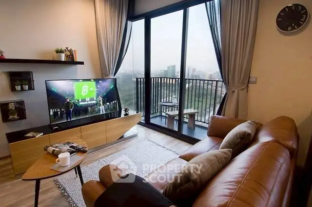 Stylish living room with leather sofa and balcony view in modern apartment