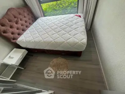 Cozy bedroom with a plush bed and large window offering natural light.