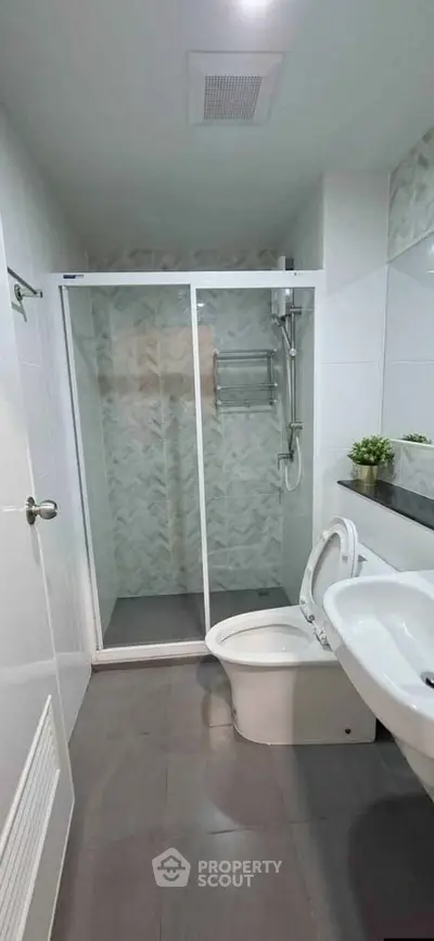 Modern bathroom with glass shower enclosure and sleek fixtures