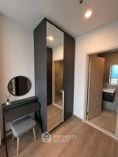 Modern bedroom with stylish vanity and ensuite bathroom in a contemporary apartment.