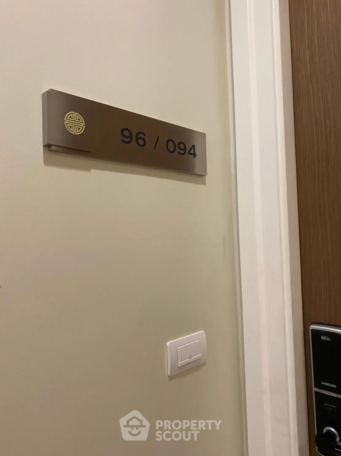 Modern apartment door with sleek number plaque and electronic lock system.