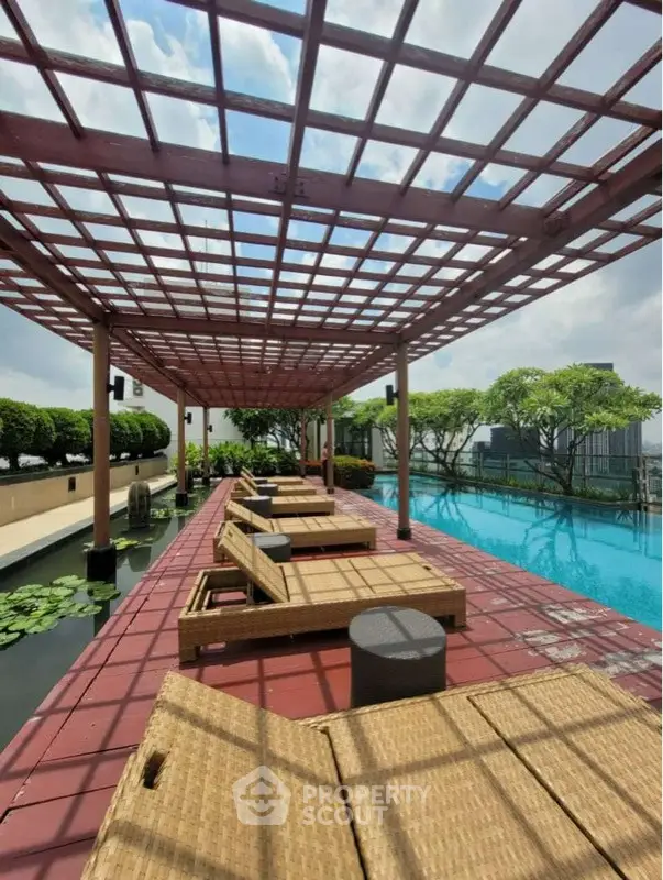 Luxurious rooftop pool with stylish lounge chairs and pergola, offering a serene urban escape.