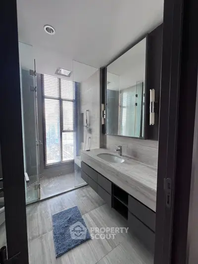 Luxurious modern bathroom with sleek design and city view, featuring a spacious shower and elegant vanity.