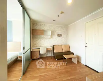Modern apartment interior with cozy living area and study desk, featuring wooden flooring and stylish decor.