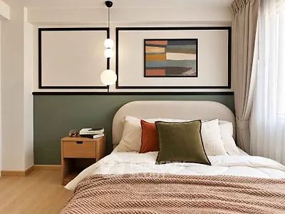 Stylish bedroom with modern decor and cozy bedding in a well-lit apartment.